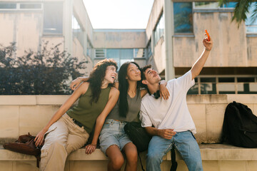 Cheerful multi-ethnic student friends taking a selfie with each other