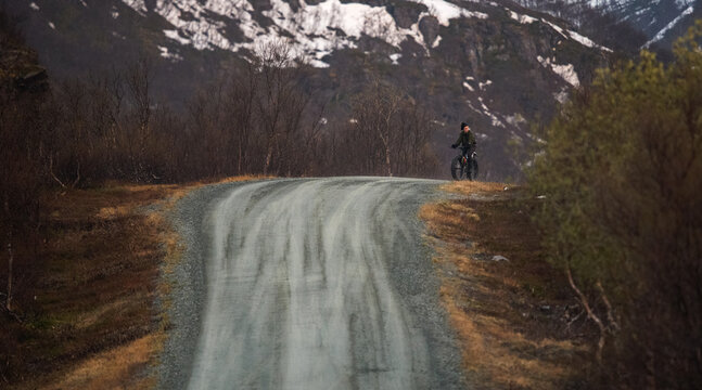 Woman riding a fatbike on a gravel dirt road