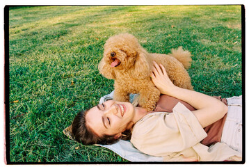 Young happy woman cuddling her dog in the park