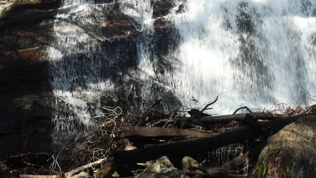 slow motion footage of the rushing waters of Smith Creek and waterfall at Anna Ruby Falls with rocks and lush green trees and plants in Helen Georgia USA