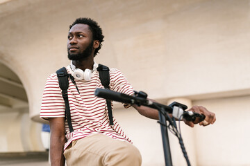 Black man with electric bicycle on college campus