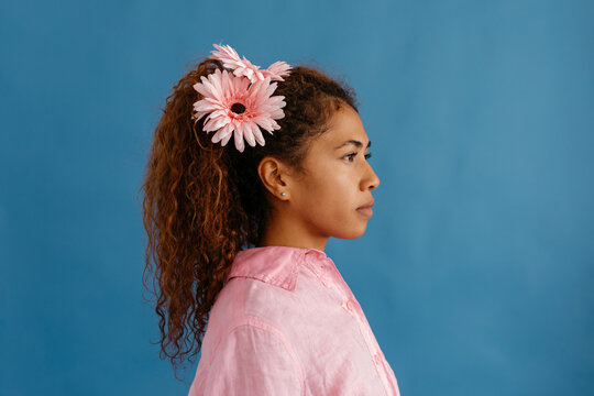 Hispanic young woman with gerbera flowers in hair