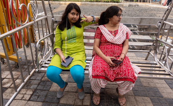 Mother and Daughter sit on a swing together and relaxing