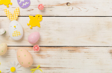 Naklejka premium Easter eggs and cute decoration on wooden background, top view