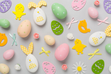 Easter eggs and cute decoration on color background, top view