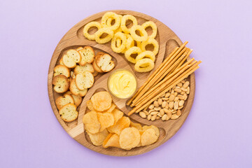 Different tasty snacks with sauce on color background, top view