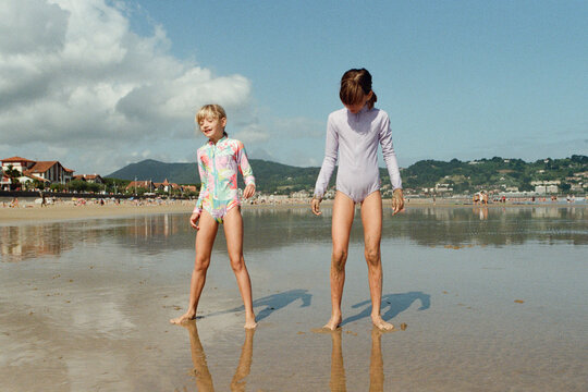 Two girls in swimming suits with long sleeves.