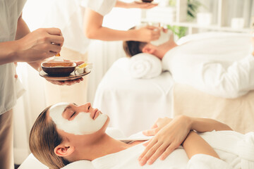Obraz na płótnie Canvas Serene ambiance of spa salon, couple indulges in rejuvenating with luxurious face cream massage with modern daylight. Facial skin treatment and beauty care concept. Quiescent