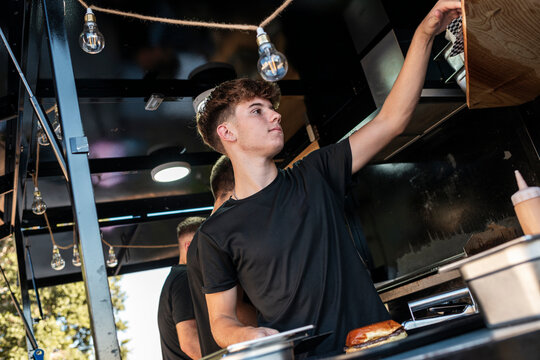 Food Truck Worker Reaching for Supplies During Rush