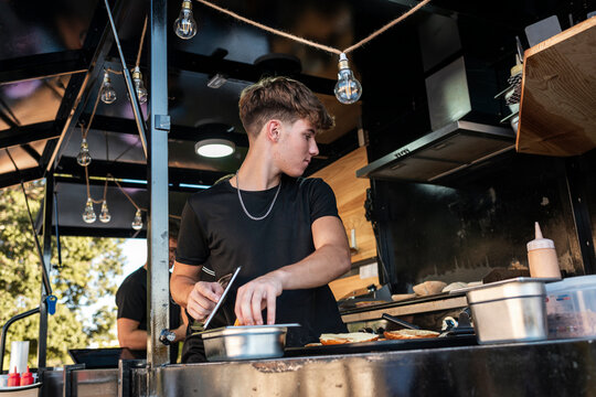 Chef Seasoning Sandwiches on Food Truck Counter