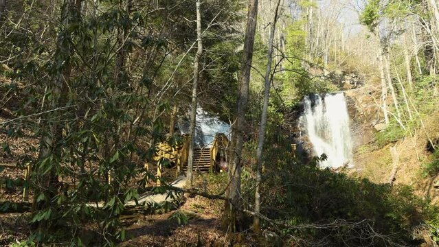 panning footage of the rushing waters of Smith Creek and waterfall at Anna Ruby Falls with rocks and lush green trees and plants in Helen Georgia USA