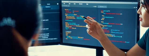 Young Professional website developer and cooperative computer engineer team brainstorming and sharing idea of program writing and coding at modern meeting room. Teamwork concept. Closeup. Burgeoning.