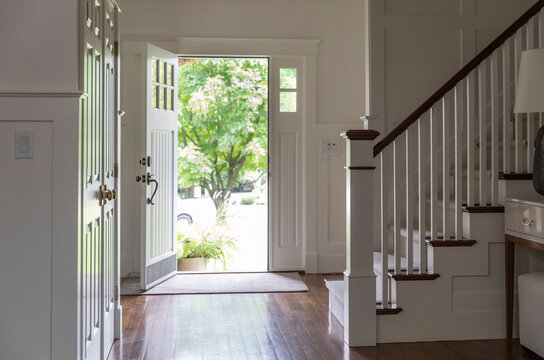 Contemporary Home open front door in foyer with staircase 