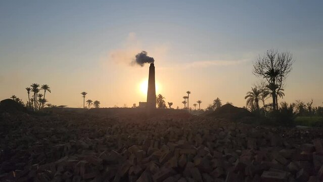 a brick kiln factory where they are baking clay into bricks used for construction at sunset. View of a brick kiln, Bricks making factory, construction materials. Environmental problem pollution.