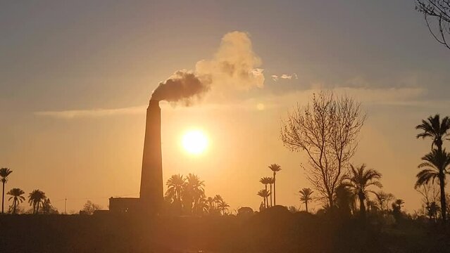 a brick kiln factory where they are baking clay into bricks used for construction at sunset. View of a brick kiln, Bricks making factory, construction materials. Environmental problem pollution.