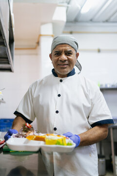 Smiling chef holding peruvian food