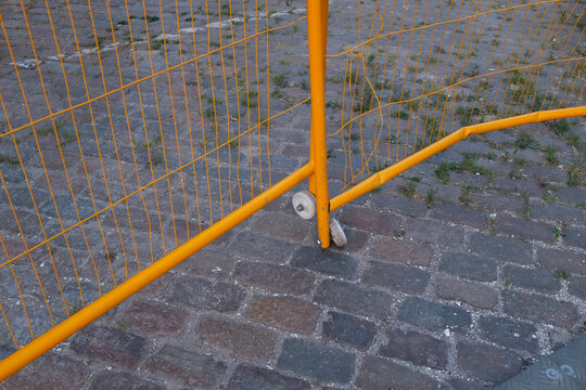 Yellow metallic fence and cobblestones