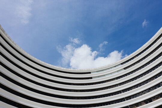 The arc-shaped building against the sky and clouds