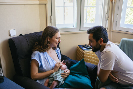 Woman breastfeeding her baby at home.