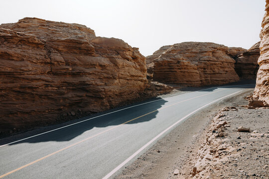Curved Desert Road Through Rock Formations