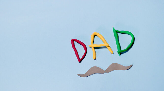 The word "dad" is written in red, yellow, and green letters. The image conveys a playful and humorous mood. fathers day