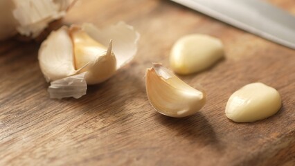 Fototapeta na wymiar Garlic cloves on a wooden cutting board. Close-up, shallow dof.