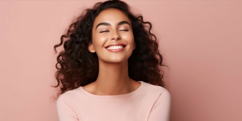 Delighted lady with curly hair, laughing heartily. Pink background. Concept of happiness, beauty, spontaneous joy, lightheartedness, joyful moments, and positive lifestyle. Banner. Copy space