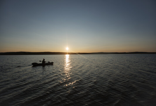 Woman paddling a packraft on a calm body of water