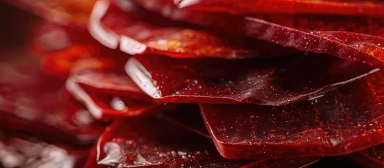 Photo sur Aluminium Piments forts A detailed view of a stack of red hot chili peppers that have been dried and sliced, creating a visually striking image of vibrant red candy-like shapes.