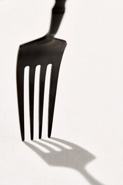 the shadow of a fork on a tablecloth