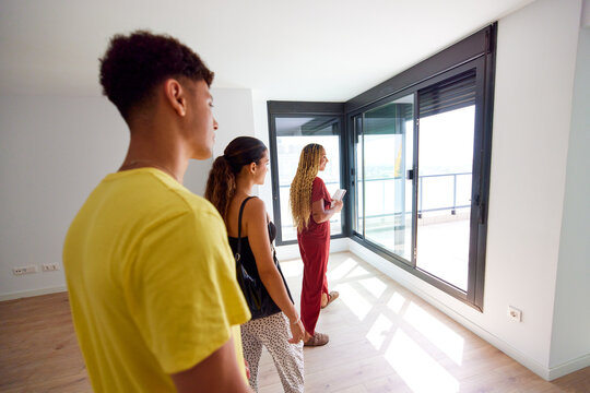 Female realtor introducing apartment to young couple