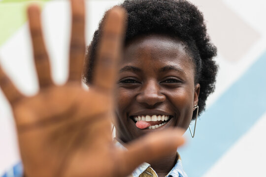Joyful black woman showing tongue and stop sign