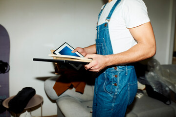 Anonymous man carries household items