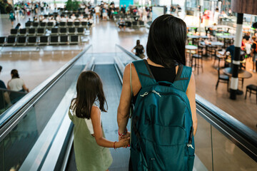 Girl with mother on moving walkway in airport