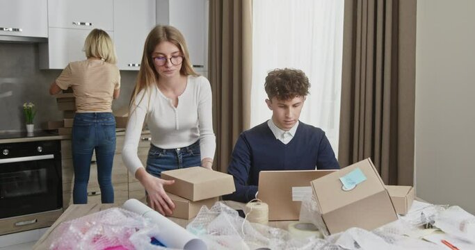 Dynamic Young Team Packaging Parcels for Small Business from Apartment