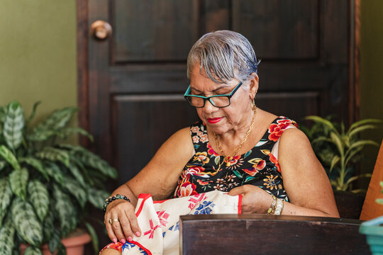 Grandmother embroidering on fabric. 