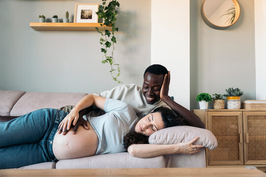Pregnant Couple lying On The sofa