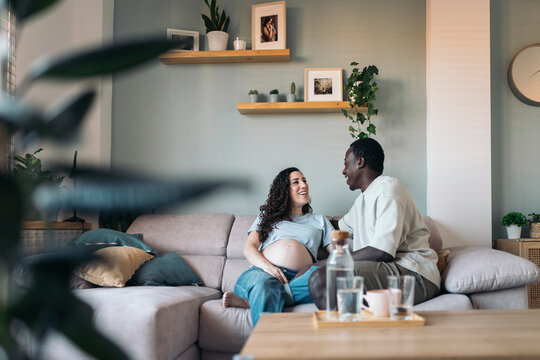 Happy Pregnant Couple Talking At Home