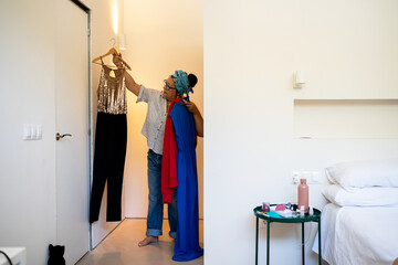 woman choosing clothes in walking closet 