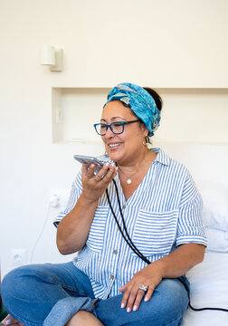A Woman Is sending audio message On Her Mobile At Bedroom 