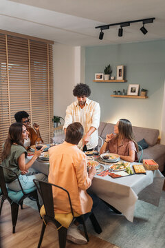 Diverse Friends Having Dinner at home While having fun