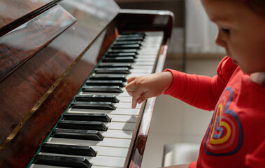 crop of little girl hand learning to play the piano