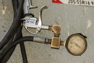 Close-up photography of a broken pressure gauge and an air chuck attached to a hose, in a car workshop in the town of Arcabuco in central Colombia.