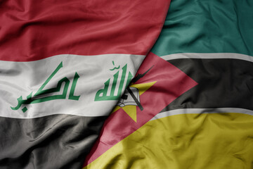 big waving national colorful flag of mozambique and national flag of iraq.