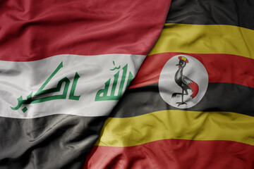 Fototapeta premium big waving national colorful flag of uganda and national flag of iraq.