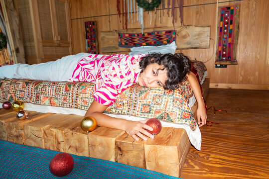 Young Asian woman lying in wooden bedroom with Christmas decorations