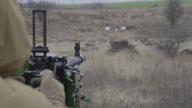 A soldier fires a machine gun, close-up, the end of the machine gun belt