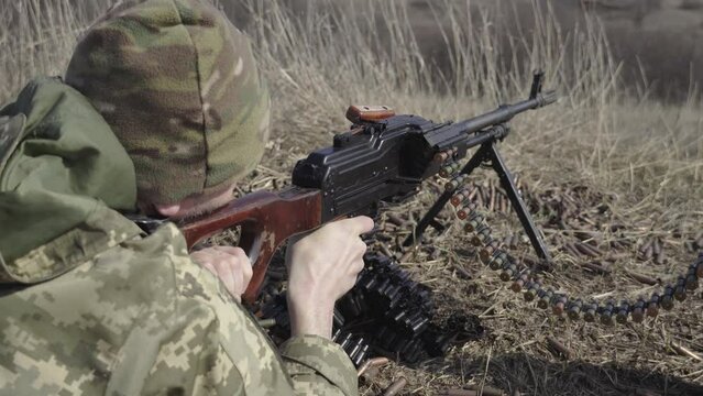 A soldier fires a machine gun, close-up, the end of the machine gun belt. RPK