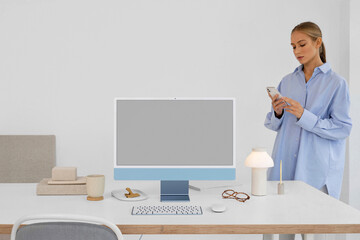 a business woman in a modern office near a computer with white screen