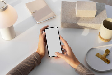 Mockup of a modern phone with white  screen. bright workplace